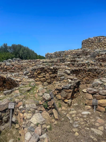 Arzachena, Costa Smeralda, Sardinya - 15 Temmuz 2024: Nuraghe La Prisgiona, nuragic arkeolojik alan. Mavi gökyüzünün altında kayalar, gri-kahverengi taşlar