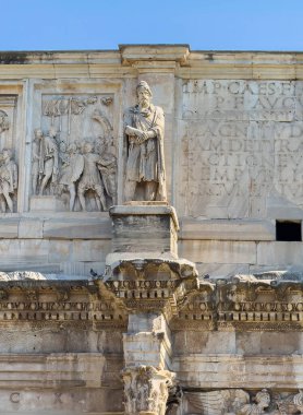 Roma, İtalya - 16 Temmuz 2024: Kolezyum. Konstantin Kemeri, tarihi anıtın sol üst yarısındaki, güneye bakan ikinci heykele odaklan.