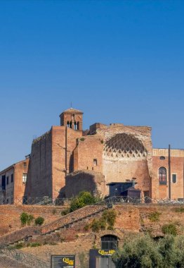 Roma, İtalya - 16 Temmuz 2024: Kolezyumdan Batı 'ya bak: Bazilika di Santa Francesca kulesi Venüs Tapınağı ve Roma' nın doğu tarafındaki kalıntılarını mavi gökyüzünün altında dikizliyor.