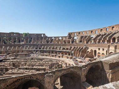 Roma, İtalya - 16 Temmuz 2024: Yerin üstünde Kolezyum çemberinin yarısı ve mavi gökyüzünün altında toplanma alanının yarısı