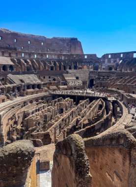 Roma, İtalya - 16 Temmuz 2024: Kolezyum. Kısmen örtülü olan toplanma alanına ve kısmen gitmiş olan oturma alanına bakıyorum. Şimdi büyük delikleri var. Turistler burada