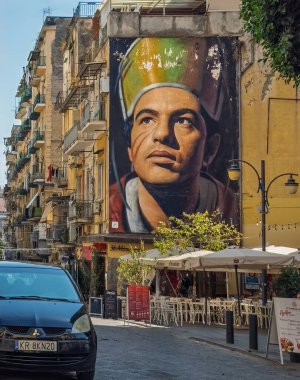 Napoli, İtalya - 17 Temmuz 2024: Vicaria Vecchia alışveriş caddesi. Şehrin koruyucu azizi San Gennaro 'nun dev fotoğrafı meydanda, Piazza Crocelle ai Mannesi, iki kilisenin. Bistro ve diğer perakende şirketleri