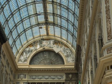 Napoli, İtalya - 17 Temmuz 2024: Galleria Umberto 1, camdan kanatlı alışveriş merkezi. Heykel duvarlar ve kemerler