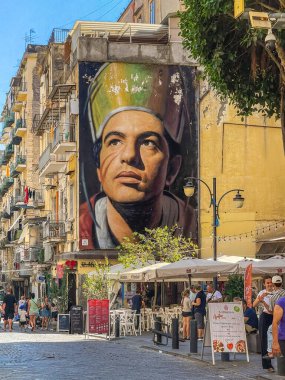 Napoli, İtalya - 17 Temmuz 2024: Vicaria Vecchia alışveriş caddesi. Şehrin koruyucu azizi San Gennaro 'nun dev fotoğrafı meydanda, Piazza Crocelle ai Mannesi, iki kilisenin. Bistro ve diğer perakende şirketleri