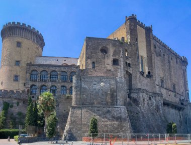 Napoli, İtalya - 17 Temmuz 2024: Tarihi Castel Nuovo köşe kulesi, surlar ve bina.