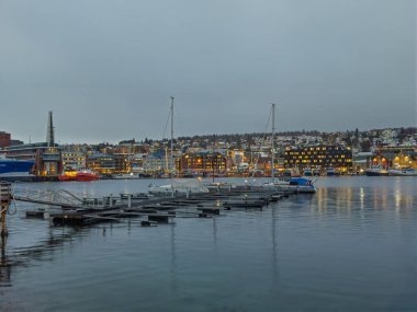 Tromso, Norveç - 23 Aralık 2025 Lokta 'dan görünen şehir manzarası, adı Loop olan, neredeyse boş bir yat rıhtımına sahip bir rıhtım.