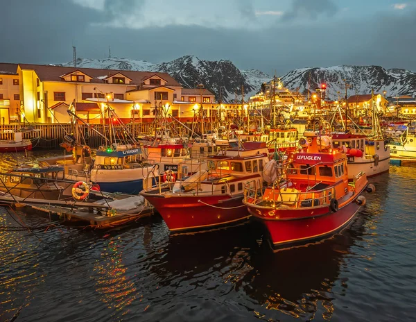 Honningsvag, Norveç - 24 Aralık 2025: Birçok balıkçı teknesiyle birlikte limanın SW tarafında. Brygge Oteli ve restoranı karla kaplı dağın altında ve öğle vakti