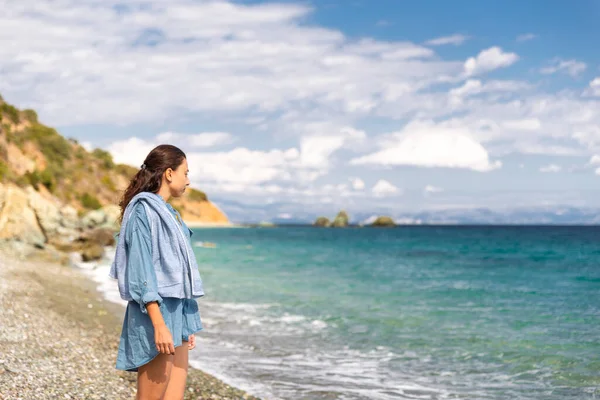 Young beautiful woman looking at sea landscape view, Livadi beach vacation, tourist destination Greece travel, Europe.