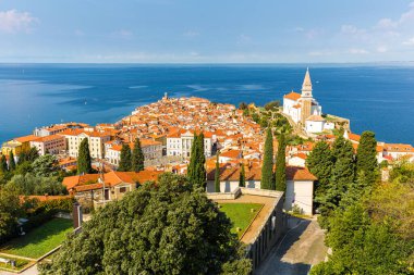 Piran kıyı kenti manzarasının üzerinde eski merkez binalar kırmızı çatılar, kale antik taş duvarlar Slovenya seyahati, Avrupa turizmi ünlü tatil beldesi.