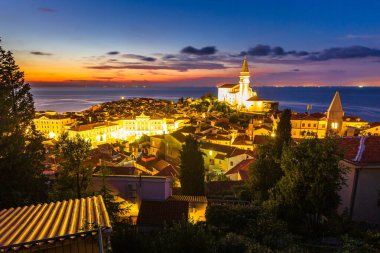 Akşam üstü alacakaranlık manzarası Piran yarımadası kıyı kenti eski binalar gezinti güvertesi, Slovenya