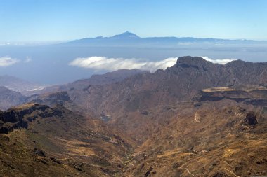 Arkaplanda Tenerife 'nin bulunduğu Roque Nublo (Bulutlardaki Kaya) kayalarından Gran Kanarya Dağları manzarası.