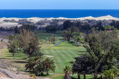Maspaloma 'da golf sahası, arka planda kum tepeleri olan Gran Canaria..