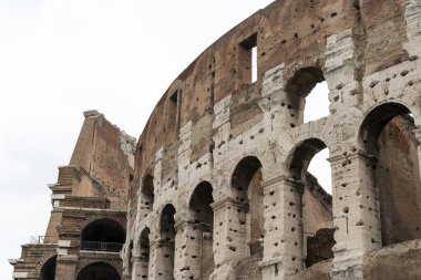 Roma, İtalya 'da bulutlu bir yaz gününde Kolezyum. Kolezyum, Roma Forumu 'nun hemen doğusunda, İtalya' nın başkenti Roma 'nın merkezinde bulunan oval bir amfitiyatrodur..