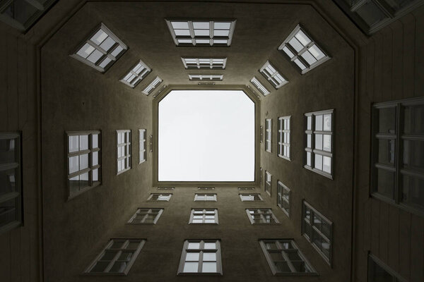 Bottom-up view from a rectangular courtyard in Vienna on a summer day.