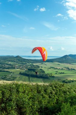 Csobanc, Macaristan - 20 Ağustos 2021: Macaristan 'da bir yaz günü Balaton Gölü' nün üzerinden geçen paraglider.