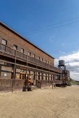 Eski ahşap yapıda büyük bir açık merdiven ve yakınlardaki su kulesi bulunur. Açık gökyüzü bu tarihi yerin cazibesini artırıyor, keşif ve hikaye anlatımına davetiye çıkarıyor..