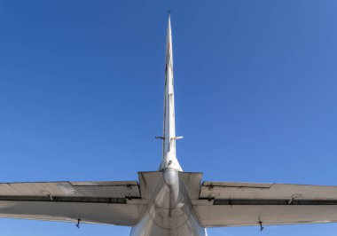 ILJUSIN IL-18V uçağının kuyruk kısmı düşük açıyla gösterilir. Gökyüzü açık ve parlak. Görünürde bulut olmadan yapıyı yakalıyor..