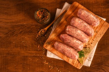 Tahta üzerinde chimichurri olan Brezilya usulü domuz sosisi.