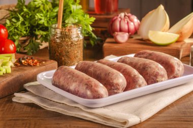 Beyaz tabakta chimichurri ve baharatlı Brezilya domuz sosisi.