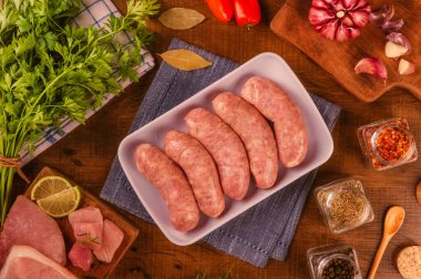 Brezilya domuz budu sosisi beyaz tabakta, baharatlar ve malzemelerle.