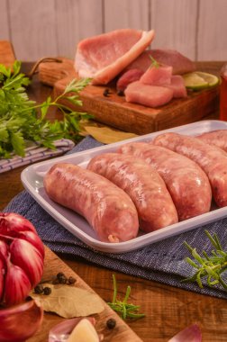 Brezilya domuz budu sosisi beyaz tabakta, baharatlar ve malzemelerle.