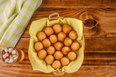 Tahta arka planda Guarana sodayla servis edilen kızarmış kroket porsiyonu (coxinha de frango)