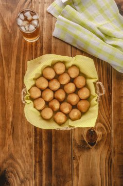 Tahta arka planda Guarana sodayla servis edilen kızarmış kroket porsiyonu (coxinha de frango)
