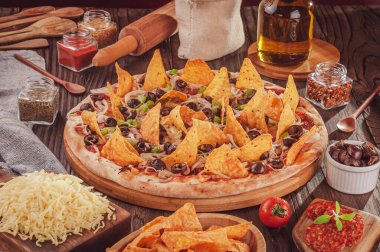 Mozzarella, soğan, pepperoni, siyah zeytin, yeşil biber, nachos ve kekikli pizza.)