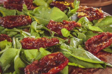 Domates soslu Brezilya pizzası, mozzarella, roka, kurutulmuş domates ve kekik (Pizza de rucula com tomate seco).