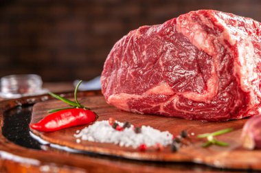 Ağaç kesme tahtasındaki çiğ et ve baharat..