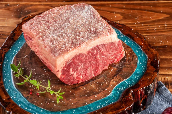 Parrilla tuzu ve baharatlarla reçinelenmiş ahşap kesme tahtasında çiğ sığır filetosu (Argentine chorizo)..