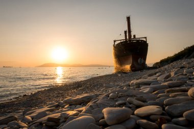 Kargo gemisi karaya oturdu. Çamurlu sahilde gün batımı