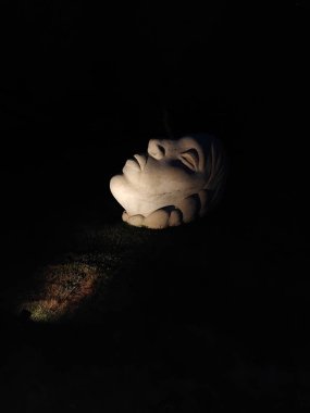 Derenivska Kupil tatil köyünün heykel parkında gece aydınlatılmış taş surat heykeli. Zakarpattia, Ukrayna, 30 Ağustos 2025