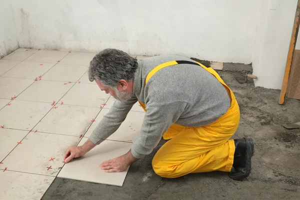 Home renovation, worker placing tile — Stock Photo, Image