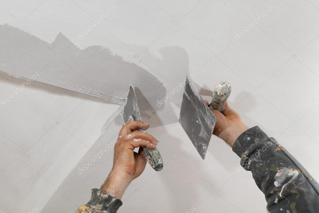 Worker Repairing Plaster At Ceiling Stock Photo