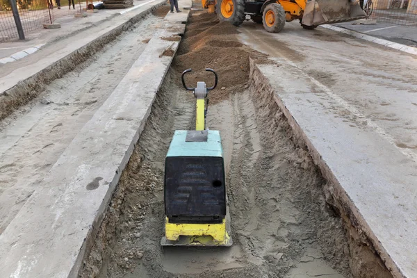 Gasoline or diesel vibratory plate compactor at road construction site — Stock Photo, Image