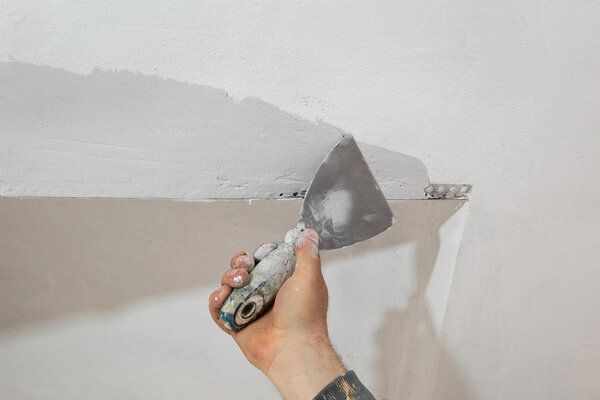 Worker install batten at ceiling and wall