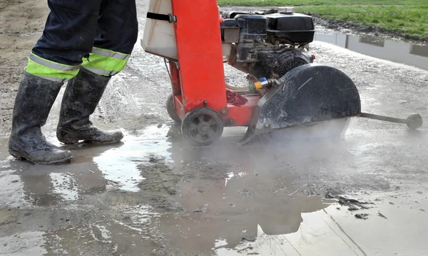 Byggarbetsplats, asfalt skärande verktyg vid vägbyggen sitta — Stockfoto