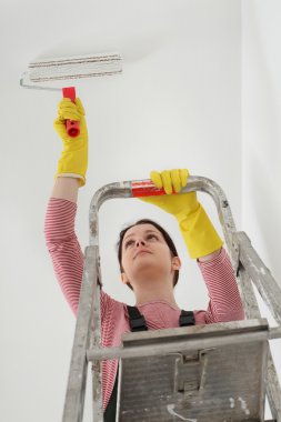 Genç bir işçi boya tavan bir odada