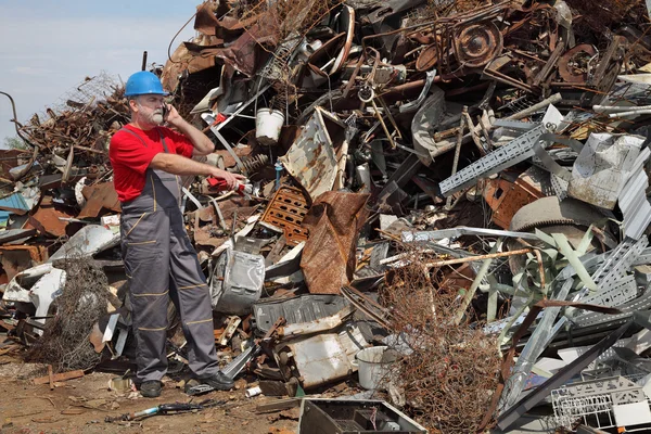 Indústria de reciclagem, trabalhador usando telefone e apontando — Fotografia de Stock