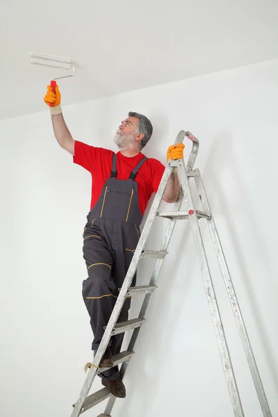 Arbeiter streicht Zimmer auf weiß — Stockfoto