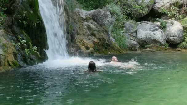 Schwimmen im See mit Wasserfall — Stockvideo