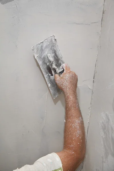 Trabajador esparciendo yeso a pared — Foto de Stock