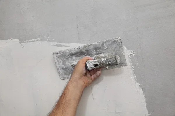 Trabalhador espalhando gesso à parede — Fotografia de Stock