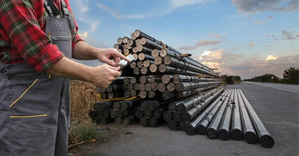 タブレットを手にした労働者と天然ガス用の絶縁パイプのヒープ — ストック写真