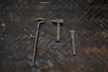 Eski hasarlı parke kaldırma araçları, çekiç, levye, beton zeminde keski, zift kaplı.