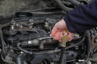 Modern demiryolu dizel motorunu tamir eden işçiler, anahtar aracı, demiryolu, boru hattı ve enjektörlerle el kapatma