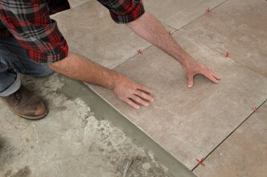 İşçi mutfak ya da banyoya seramik fayans yerleştiriyor.