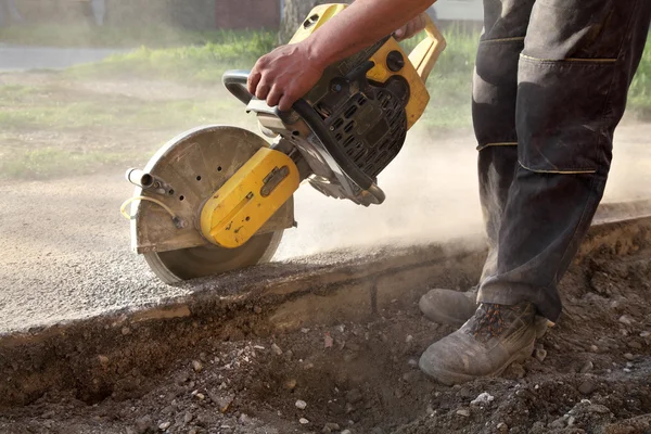 Bouwplaats, werknemer gesneden asfalt met zag blade tol — Stockfoto