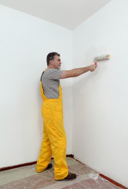 Worker painting wall in room clipart